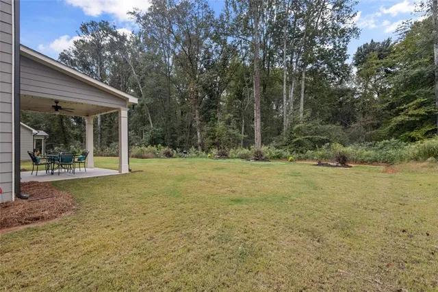 a view of a patio with a table chairs and a backyard