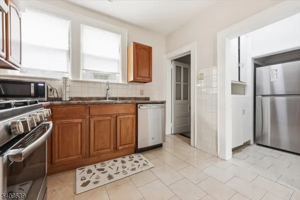 a kitchen with stainless steel appliances granite countertop a stove a sink and a refrigerator