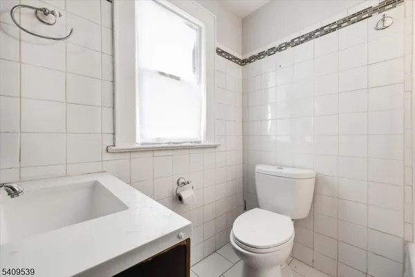 a white toilet sitting next to a bathroom sink