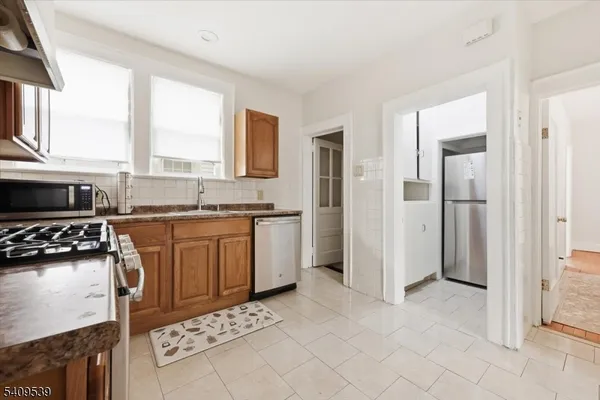 a kitchen with stainless steel appliances granite countertop a stove a sink and a refrigerator