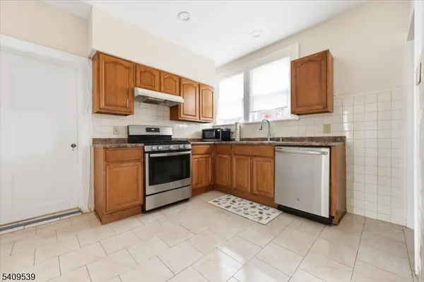 a kitchen with stainless steel appliances granite countertop a stove sink and cabinets