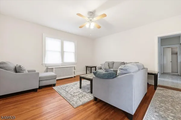 a living room with furniture and a wooden floor