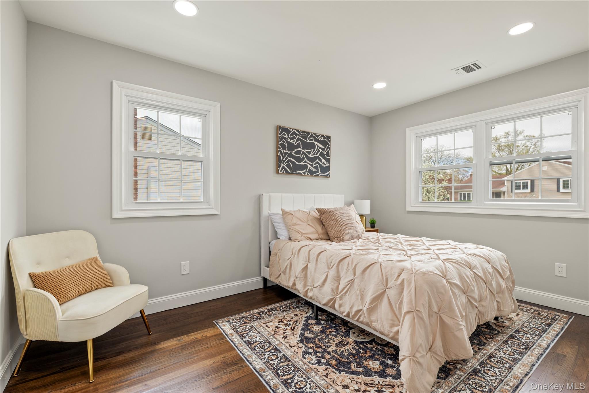16 Eleanor Road Plainview, NY 11803 - Photo 17 of 28 Hardwood flooring throughout featuring recessed ceiling lighting, multiple windows with white trim, and light-toned wall finishes