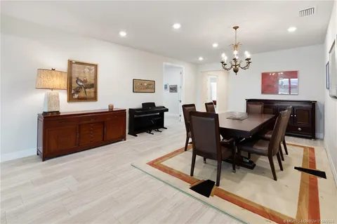a living room with furniture floor to ceiling window and a flat screen tv