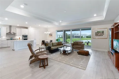 a living room with furniture a chandelier and a flat screen tv