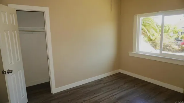 a view of small space with wooden floor and a window