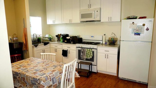 a kitchen with stainless steel appliances kitchen island granite countertop a sink stove and white cabinets