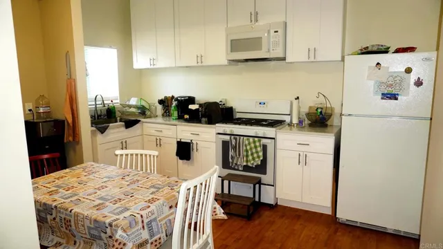a kitchen with stainless steel appliances kitchen island granite countertop a sink stove and white cabinets