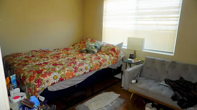 a bed sitting in a bedroom next to a window