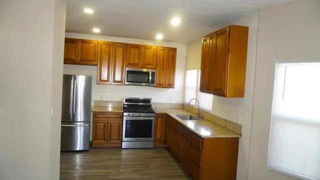 a kitchen with stainless steel appliances granite countertop a stove a sink and a refrigerator