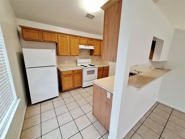 a kitchen with a refrigerator sink stove and cabinets