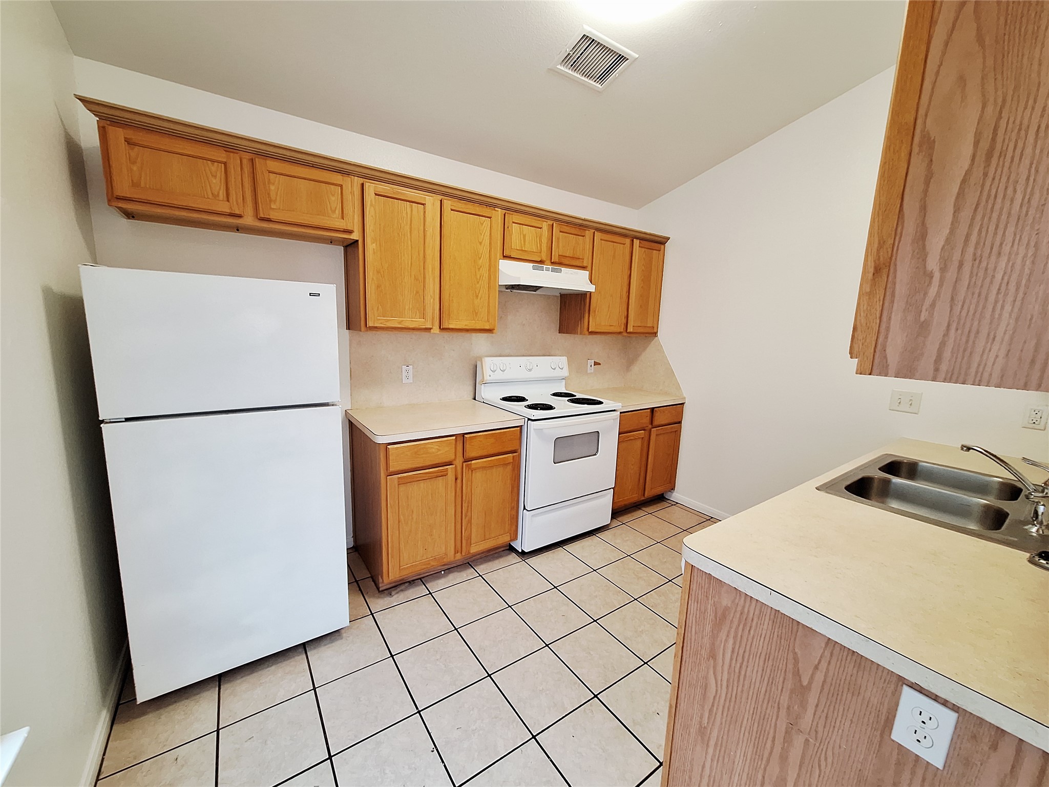 1408 Perez Street, Unit A Austin, TX 78721 - Photo 5 of 12 a kitchen with a refrigerator a stove a sink and cabinets