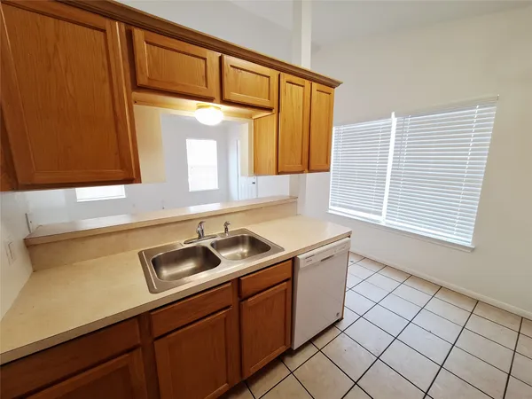 a kitchen with a sink cabinets and a window