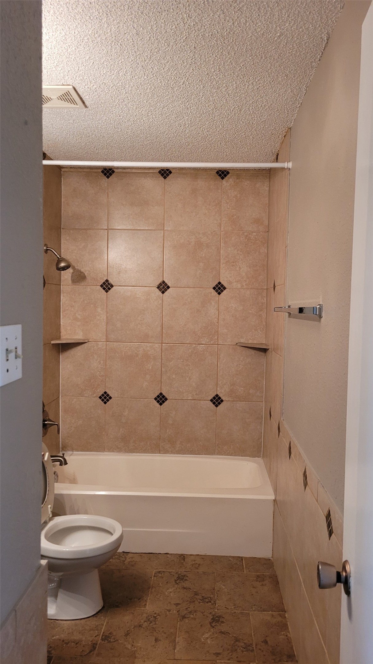 8804 Schick Road, Unit C Austin, TX 78729 - Photo 14 of 26 Bathroom featuring tub / shower combination, a textured ceiling, and stone finish flooring