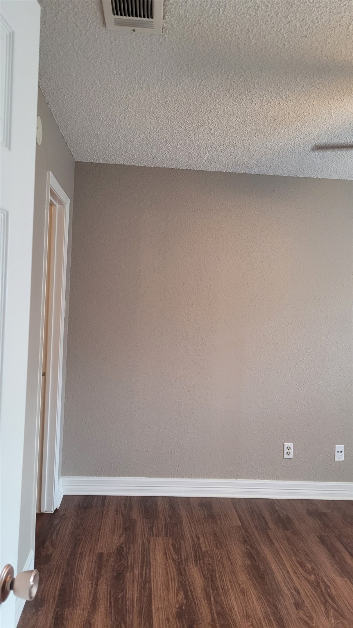 8804 Schick Road, Unit C Austin, TX 78729 - Photo 17 of 26 Empty room with a textured ceiling and dark wood finished floors