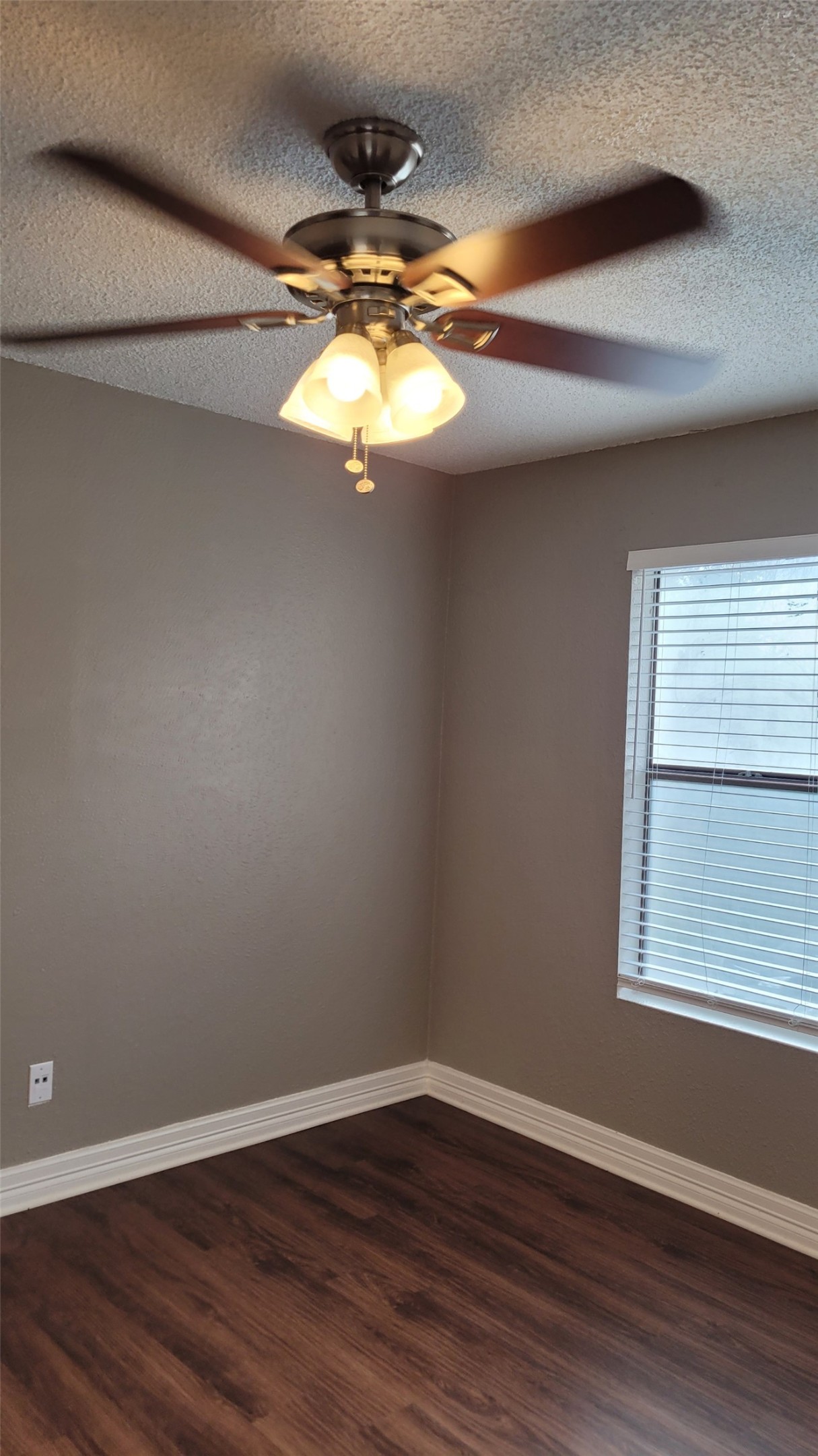 8804 Schick Road, Unit C Austin, TX 78729 - Photo 18 of 26 Empty room with dark wood-type flooring, a textured ceiling, and ceiling fan
