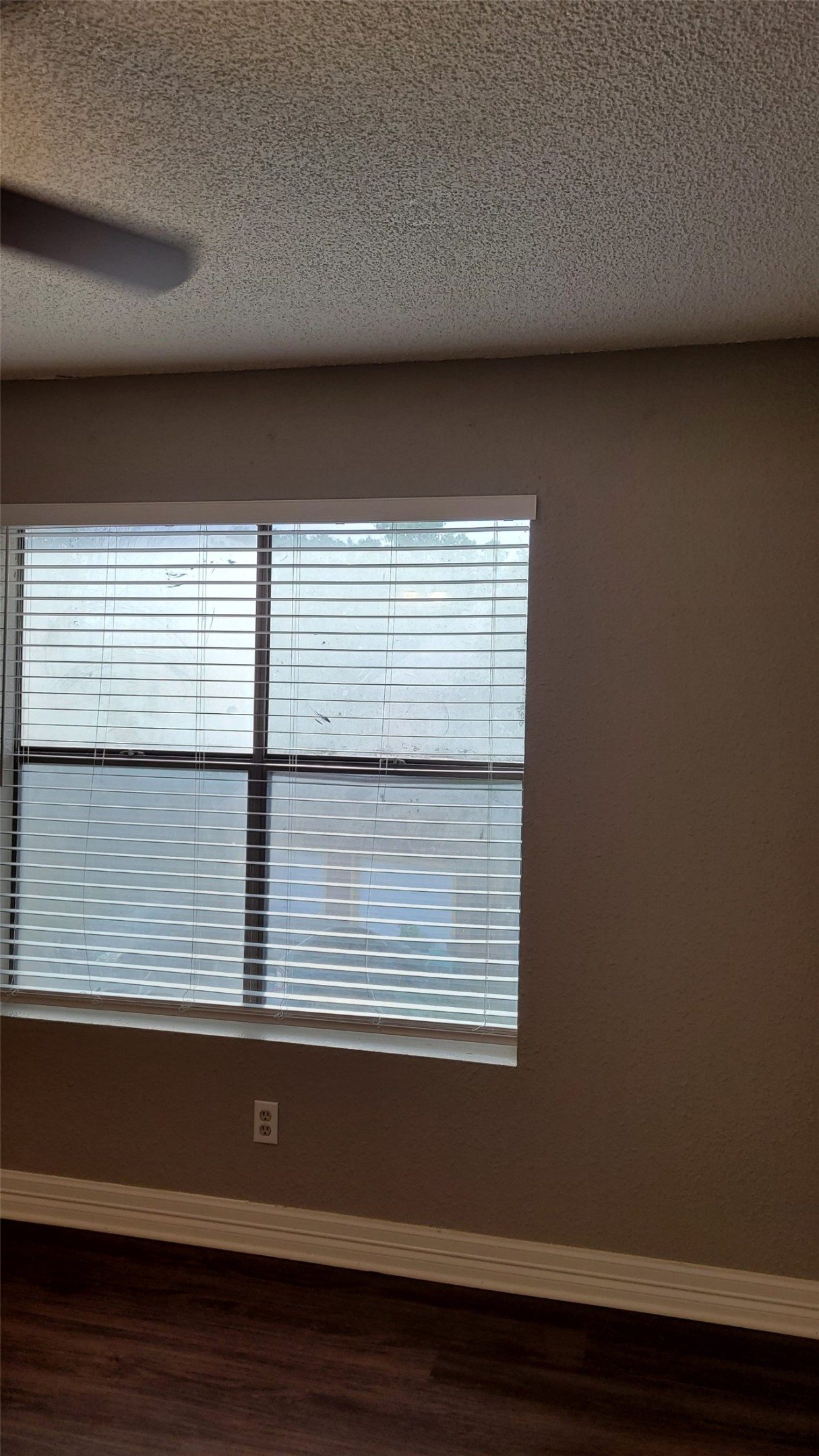 8804 Schick Road, Unit C Austin, TX 78729 - Photo 19 of 26 Empty room with a textured ceiling, plenty of natural light, a ceiling fan, and dark wood-style floors