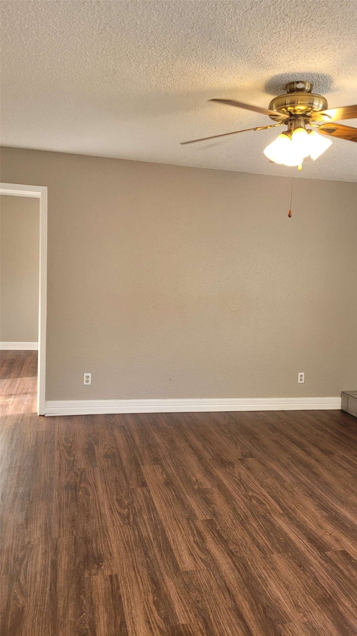 8804 Schick Road, Unit C Austin, TX 78729 - Photo 2 of 26 Unfurnished room with a ceiling fan, a textured ceiling, and dark wood-style flooring