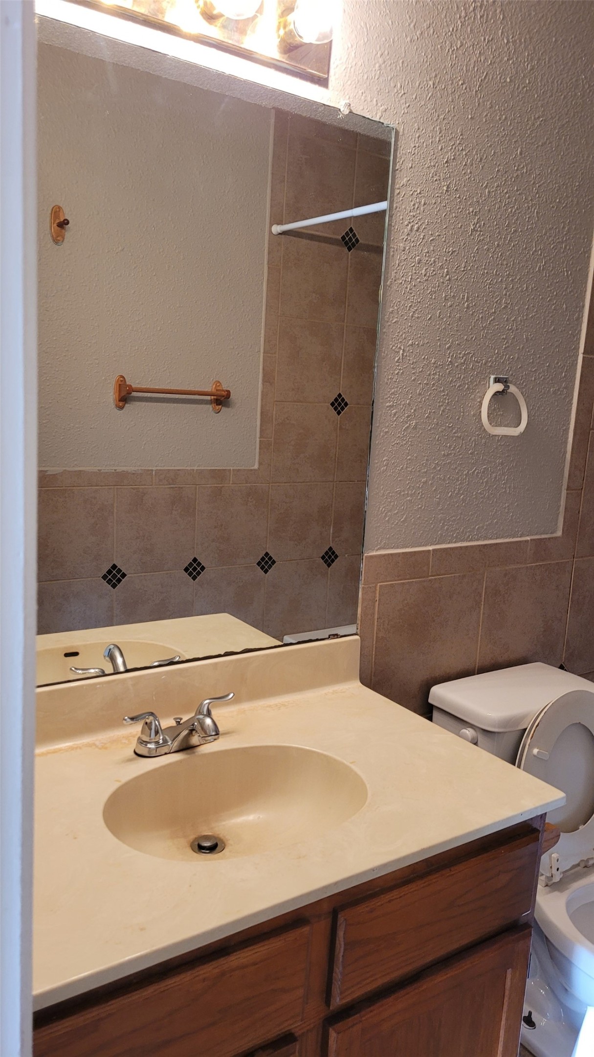 8804 Schick Road, Unit C Austin, TX 78729 - Photo 22 of 26 Full bathroom featuring a textured wall, vanity, a shower, tile walls, and a wainscoted wall