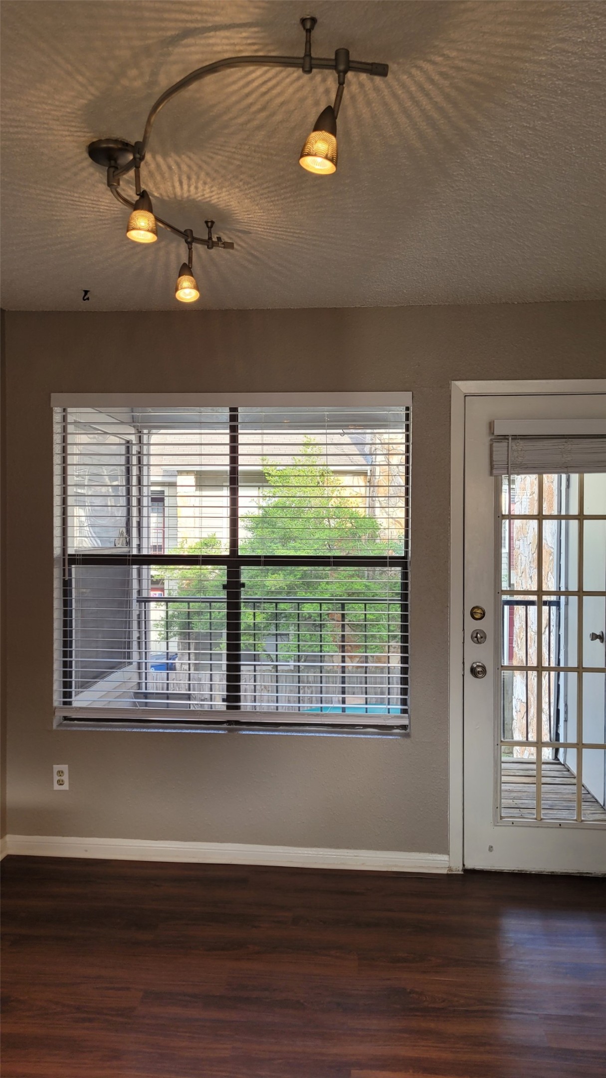 8804 Schick Road, Unit C Austin, TX 78729 - Photo 8 of 26 Empty room featuring dark wood-style floors and healthy amount of natural light