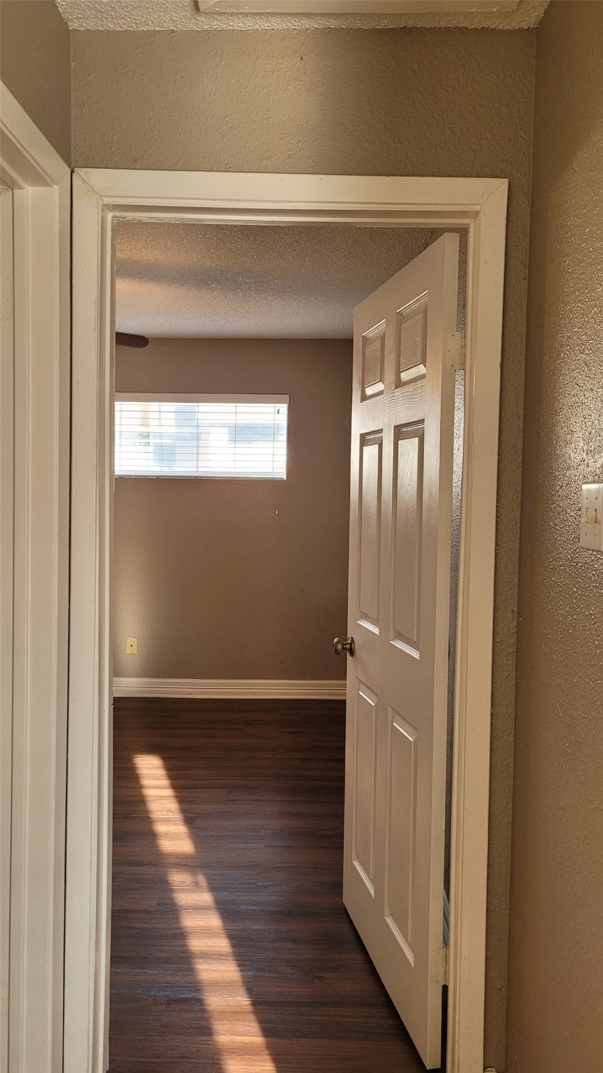 8804 Schick Road, Unit C Austin, TX 78729 - Photo 10 of 26 Hall with dark wood-style floors, a textured wall, and a textured ceiling