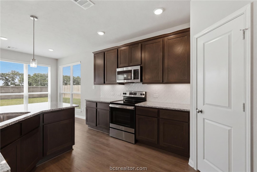 1922 Viva Road Bryan, TX 77807 - Photo 12 of 45 Open-concept kitchen featuring granite countertops, an eating bar, walk-in pantry, and seamless flow to the living room, breakfast area, and dining room.