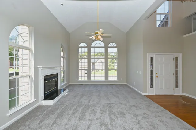 a kitchen with stainless steel appliances granite countertop a stove a refrigerator a sink a microwave oven and a dining table with wooden floor