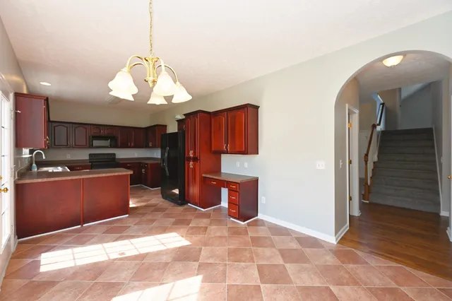an empty room with large windows and ceiling fan