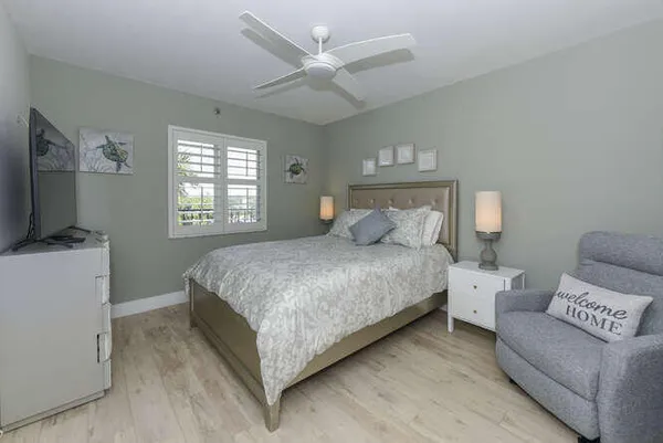 a bedroom with a large bed a flat tv screen and a chandelier