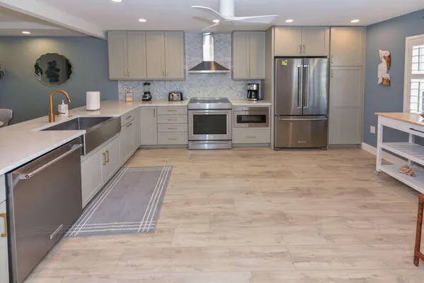 a kitchen with stainless steel appliances granite countertop a sink a stove a refrigerator and island