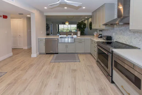 a kitchen with a sink a stove and cabinets