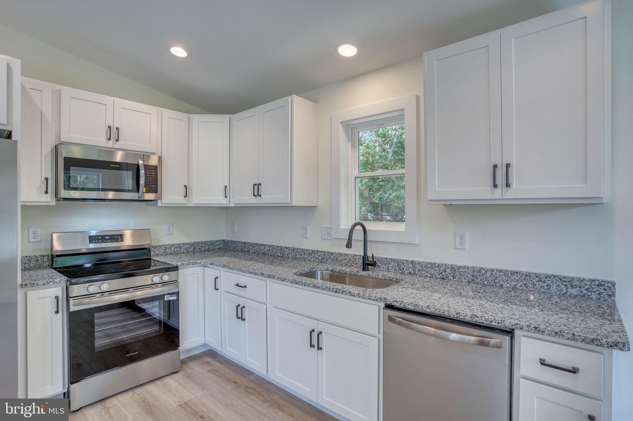 207 Charles Way Georgetown, DE 19947 - Photo 6 of 31 a kitchen with stainless steel appliances granite countertop white cabinets granite counter tops and a window