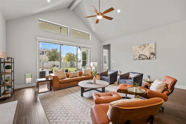 a living room with furniture and a dining table with kitchen view