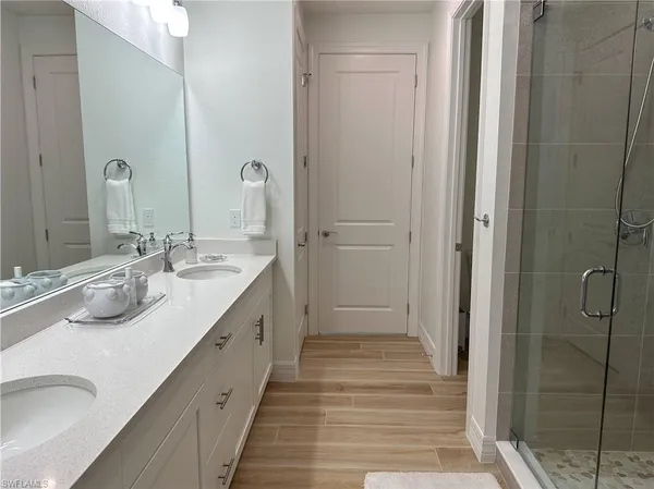 a bathroom with double vanity sinks and a shower