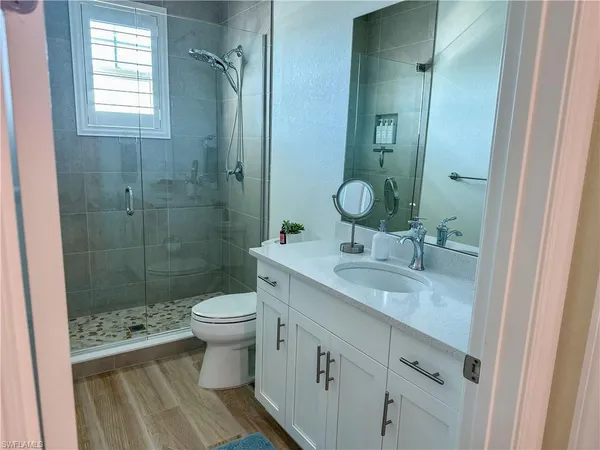 a bathroom with a sink a toilet and shower