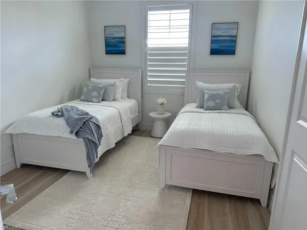 a bedroom with two beds and wooden floor