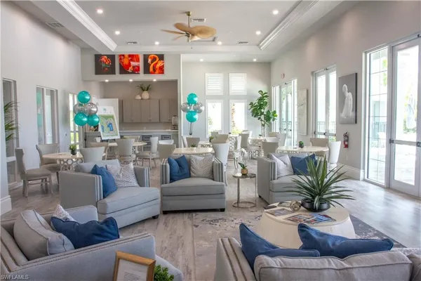 a living room with furniture kitchen view and a large window