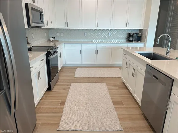a kitchen with stainless steel appliances granite countertop a sink and cabinets