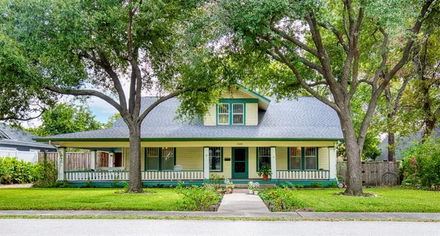 front view of a brick house with a yard