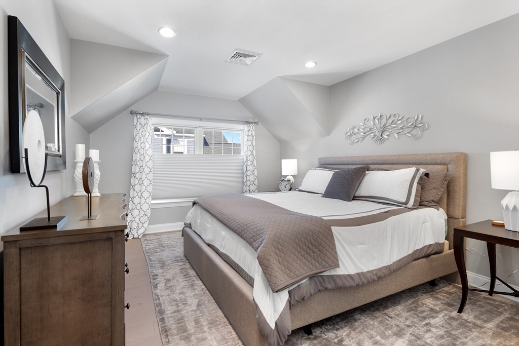 10 Benjamin Lane, Unit 10 Scituate, MA 02066 - Photo 26 of 42 a bedroom with a large bed and a chandelier