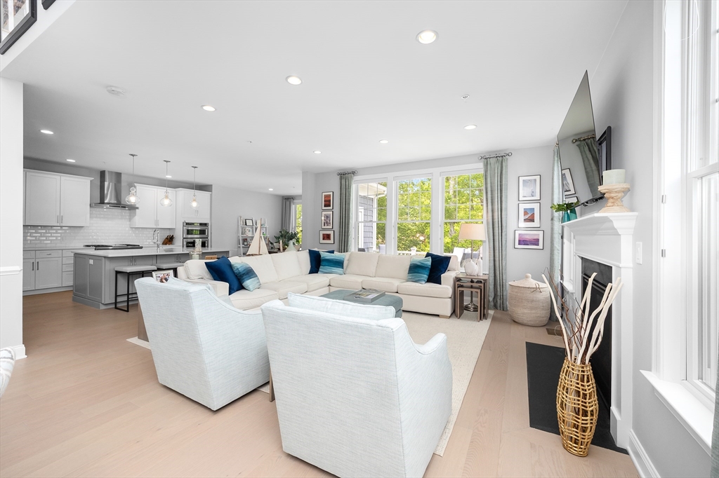 10 Benjamin Lane, Unit 10 Scituate, MA 02066 - Photo 8 of 42 a living room with fireplace furniture and a open kitchen view