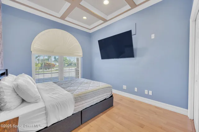 a living room with a large bed and a flat screen tv