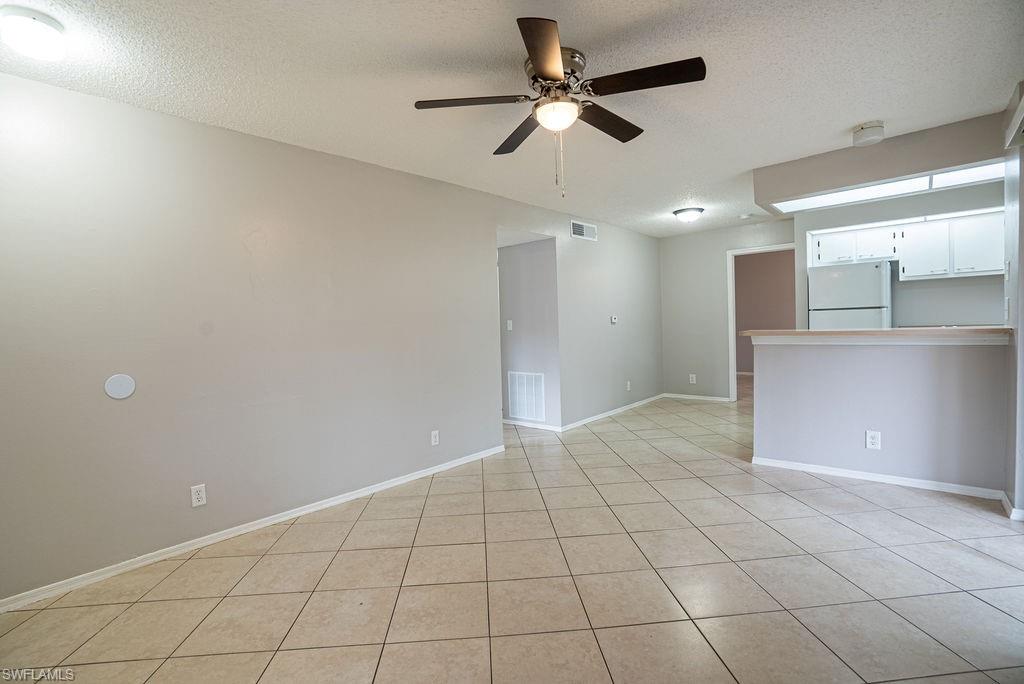2045 Rookery Bay Drive, Unit 1901 Naples, FL 34114 - Photo 5 of 18 Unfurnished room with a textured ceiling, a ceiling fan, and light tile patterned floors