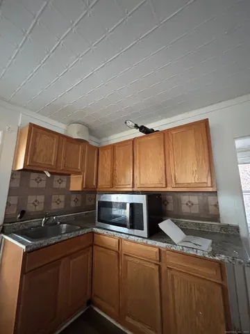 a kitchen with stainless steel appliances granite countertop a sink a stove and a microwave