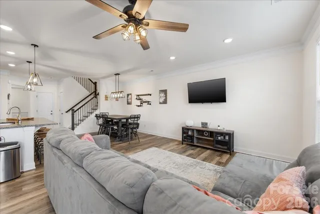 a living room with furniture and a flat screen tv with kitchen view