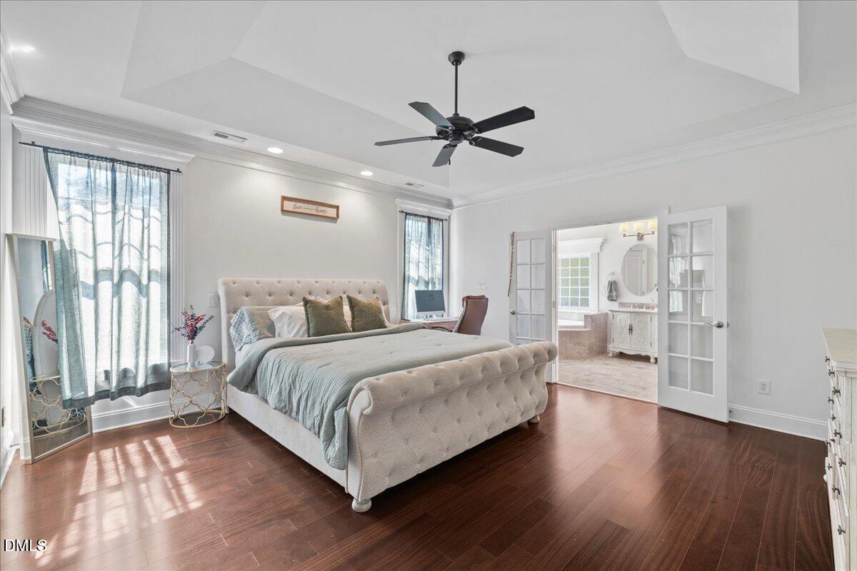1304 Flying Hawk Road Apex, NC 27523 - Photo 20 of 52 a bedroom with a large bed and a chandelier