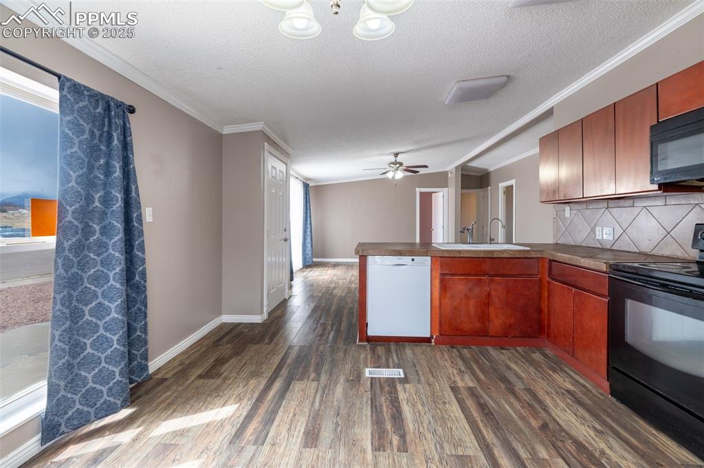254 Indian Hills Road Florence, CO 81226 - Photo 4 of 22 a kitchen with wooden floors and stainless steel appliances