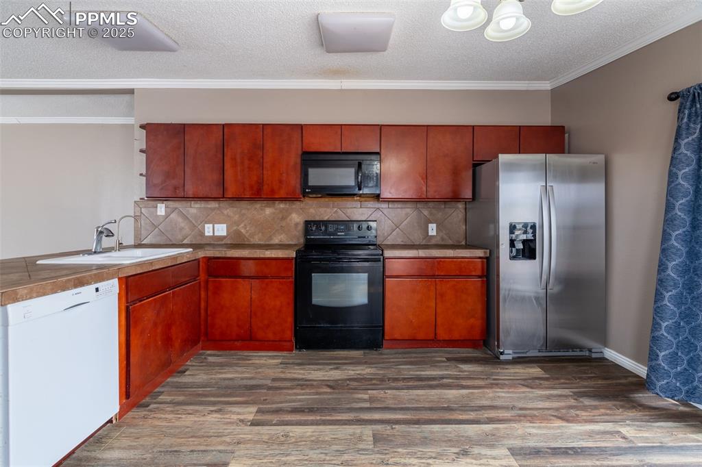 254 Indian Hills Road Florence, CO 81226 - Photo 5 of 22 a kitchen with stainless steel appliances granite countertop a refrigerator stove top oven and sink