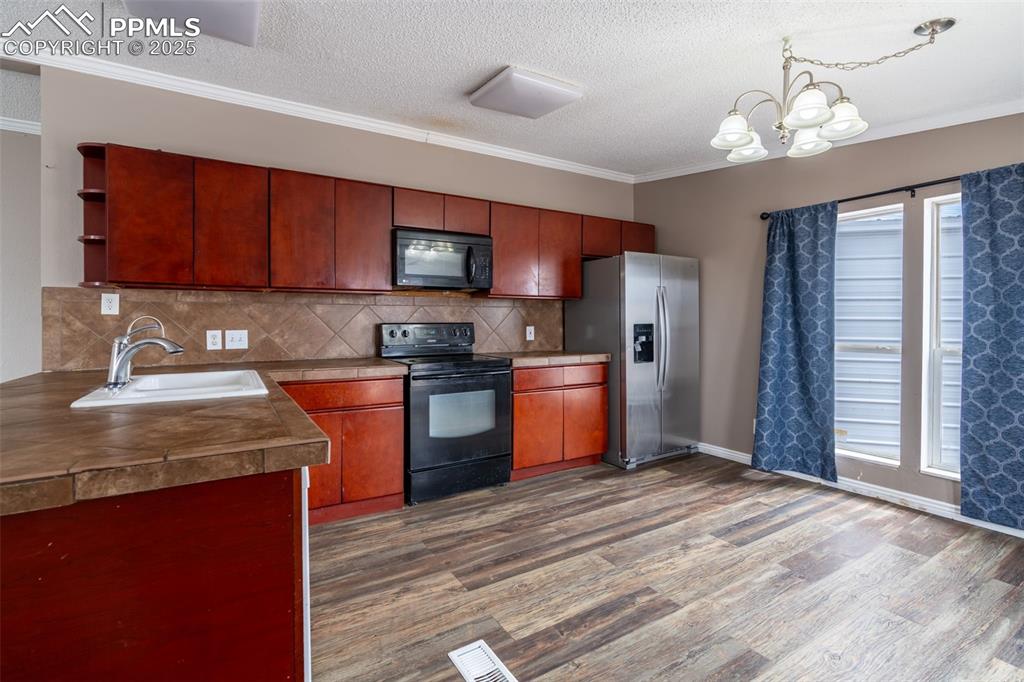 254 Indian Hills Road Florence, CO 81226 - Photo 6 of 22 a kitchen with stainless steel appliances granite countertop a sink dishwasher stove top oven and refrigerator