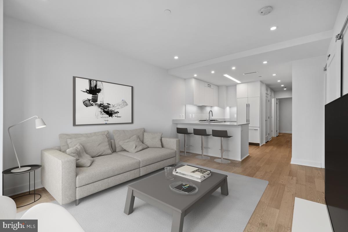 a living room with furniture and a view of kitchen